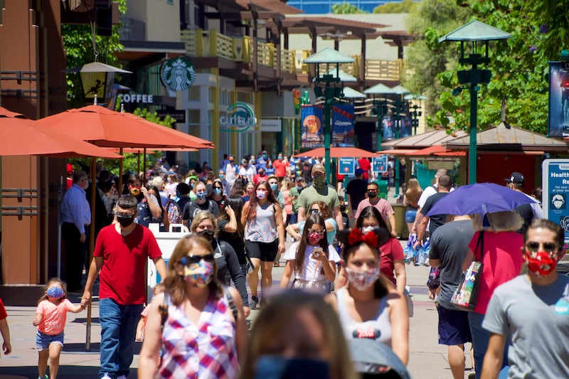 In this July 9, 2020, file photo, guests at the Disneyland Resort visit the Downtown Disney District in Anaheim, Calif.