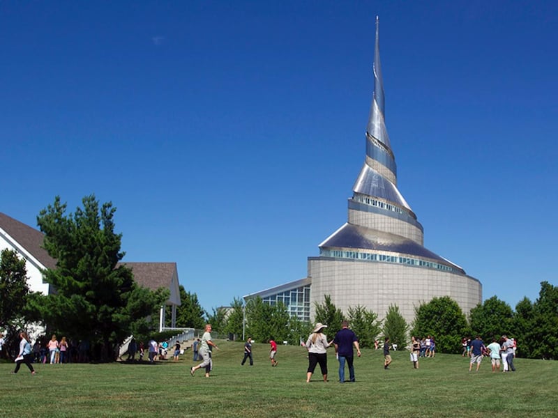 An LDS youth group from Lenexa, Kan., tours the Temple Lot in Independence, Mo., on June 23, 2017. The Church of Christ (Temple Lot), left, owns the 2.5-acre field, with the Community of Christ Temple in the background.