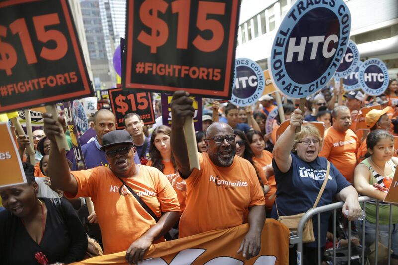 Activists cheer during a rally after the New York Wage Board endorsed a proposal to set a $15 minimum wage for workers at fast-food restaurants with 30 or more locations, Wednesday, July 22, 2015 in New York.