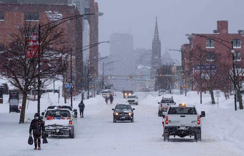 People and vehicles move about Main Street in Buffalo, N.Y.
