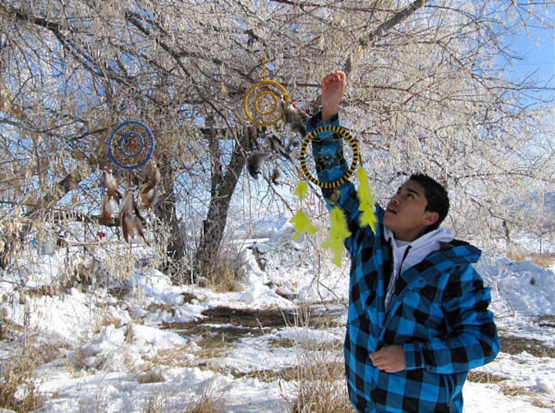 Ben Lomond High School student David Rivas, of Ogden, hangs ornaments at the Bear River Massacre site near Preston, Idaho, Jan. 29.