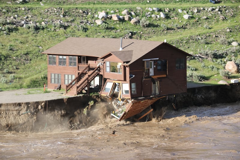 Raging flood waters slam into employee housing near Yellowstone River in Yellowstone National Park.