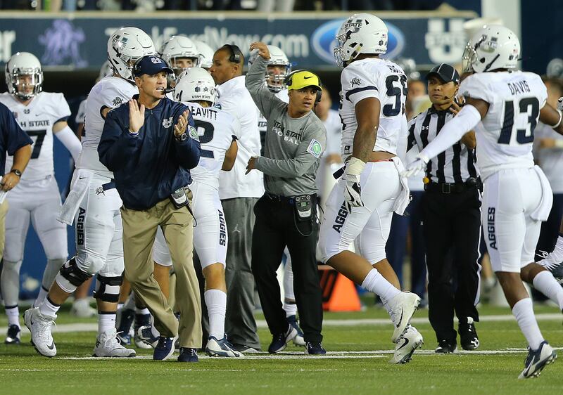 Utah State Aggies head coach Matt Wells applauds his defense as they run off the field as USU goes on to defeat BYU 40-24 at Maverik Stadium in Logan Utah on Friday, Sept. 29, 2017.