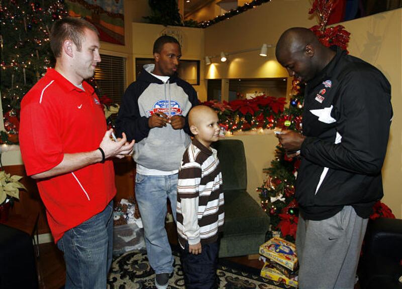 Ute players Steve Tate, left, Brian Johnson, center, and Martail Burnett talk to Jesus Tapia while at the Ronald McDonald house.