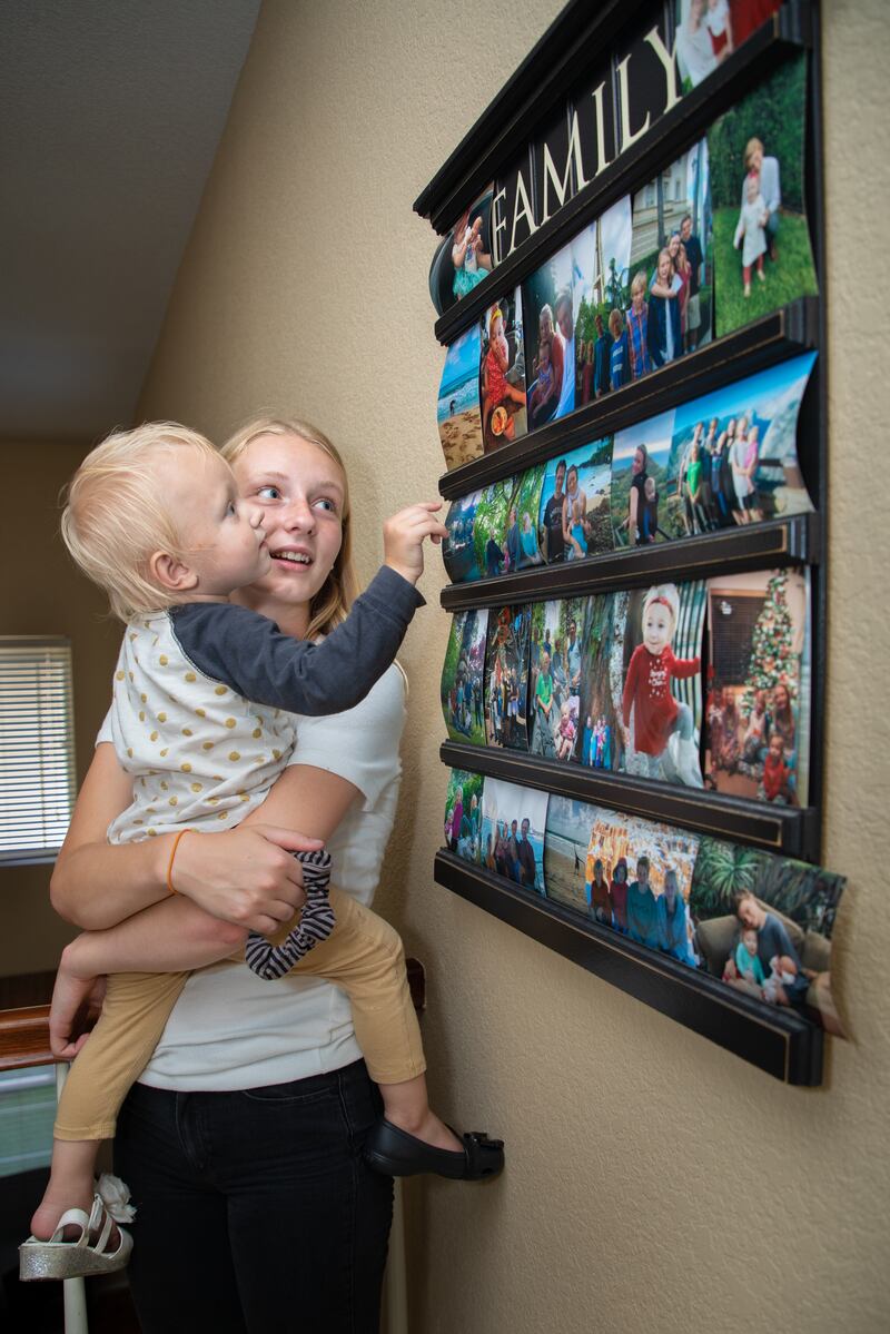 Adelaide Mitchell, 14, plays with her little sister after school on Thursday, Aug. 23, 2018, in Carlsbad, Calif. They're enjoying the family photos full of memories that line their hallways.