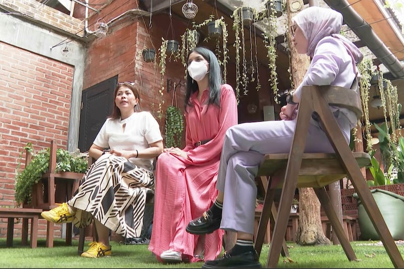 In this image made from video, Miss Universe Indonesia contestant Priskila Ribka Jelita, center, flanked by her mother, Maria Napitupulu, left, and lawyer Melisa Anggraini speaks during an interview with The Associated Press Television in Jakarta, Indonesia.