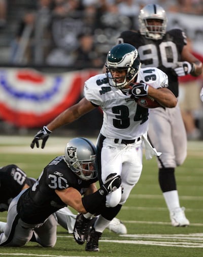 Philadelphia Eagles running back Reno Mahe is tackled by Oakland Raiders safety Stuart Schweigert Sunday, Aug. 6, 2006, in Canton, Ohio. Reid was a source of strength for Mahe after he lost his 3-year-old daughter to a tragic death two years ago.