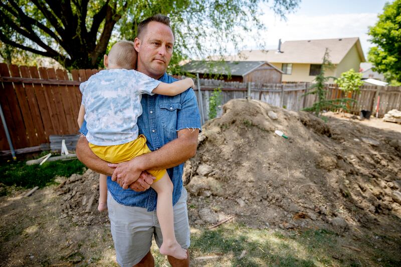Cody Jolley, who purchased a skid steer and later found it had been stolen, holds son CJ at their home in Pleasant Grove.