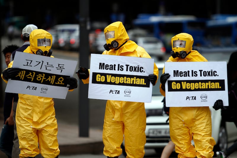 Members of People for the Ethical Treatment of Animals (PETA) Asia and Coexistence of Animal Rights on Earth (CARE) wear biohazard suits and gas masks as part of an anti-meat consumption campaign in Seoul, South Korea, Friday, Aug. 24, 2012. (AP Photo/Hye