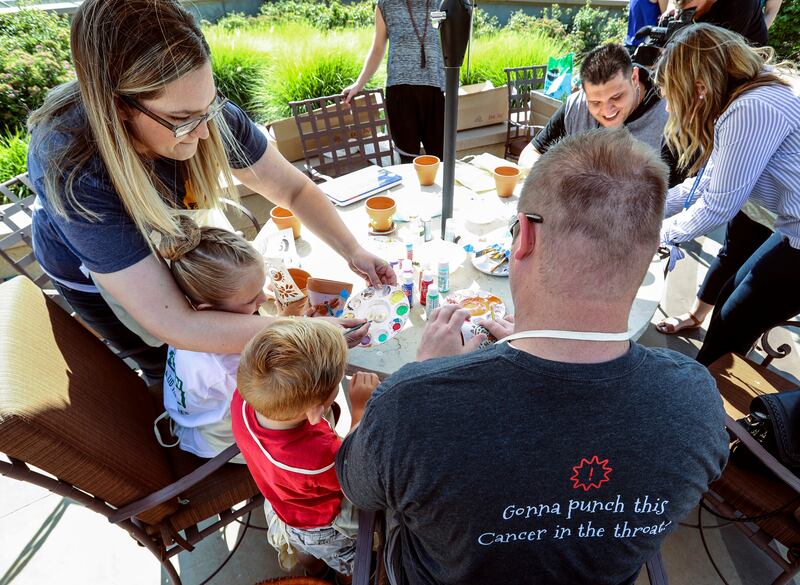 Chad Jaggi, left, his children Bella and Braden and wife Stephanie attend a sunflower planting party in honor of Sarcoma Awareness Month at the Huntsman Cancer Institute in Salt Lake City on Monday, July 30, 2018. Jaggi has angiosarcoma, a rare type of ca