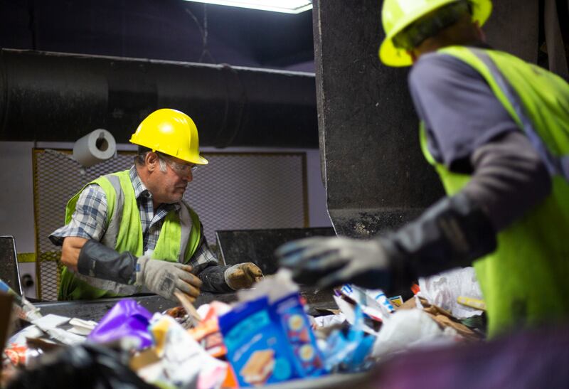 Humberto Regalado and Tomas Mager sort through trash for recyclable material at Waste Management Utah's Materials Recovery Facility in West Jordan, Utah, on Friday, May 3, 2019.