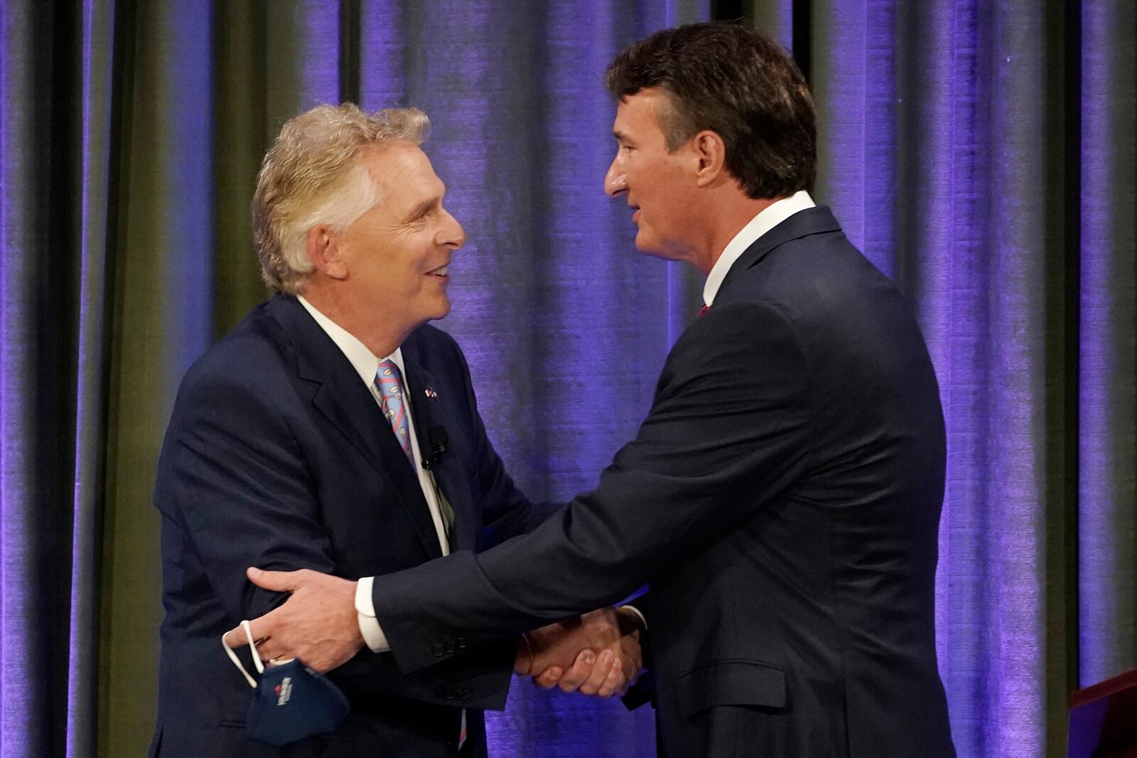Democratic gubernatorial candidate former Gov. Terry McAuliffe, left, greets Republican challenger Glenn Youngkin before a debate.