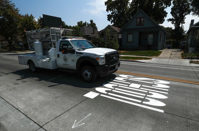 A freshly painted “SCHOOL” in large letters stretches across the westbound lane at 1700 South and Blair Street in Salt Lake City on Tuesday, Aug. 14, 2018. The Salt Lake City Public Services Department is using a new, brighter and more durable paint that