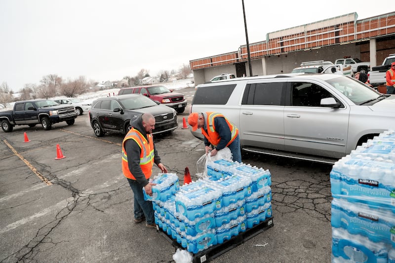 FILE - Sandy city employees Taylor Vick and Mike Fox distribute water to residents at a staging area on 700 East in Sandy on Saturday, Feb. 16, 2019.