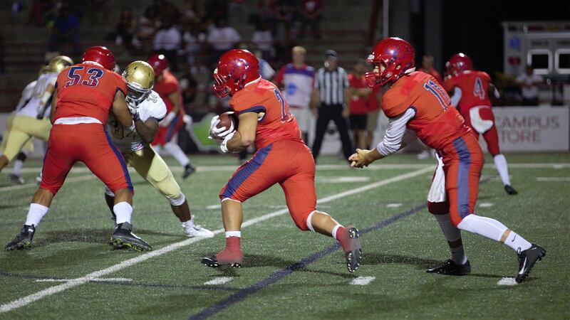 Dixie State running back Sei-J Lauago (center) takes a handoff from quarterback Trent Darms (right) in the second half of DSU's 51-47 win over South Dakota Mines on Saturday.