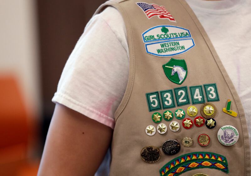 the vest of a Girl Scout is filled with badges and awards at a demonstration of some of their activities in Seattle on June 18, 2018. (AP Photo/Elaine Thompson)