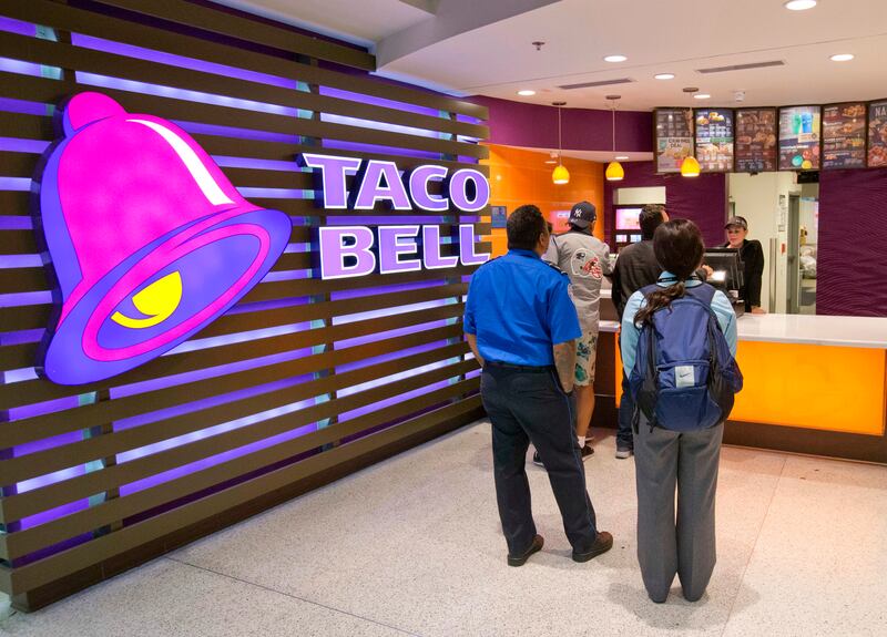 In this Oct. 17, 2017, file photo, customers line up at a Taco Bell restaurant inside Miami International Airport in Miami.