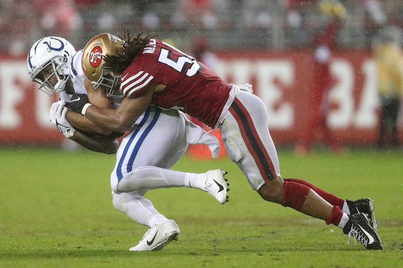 Indianapolis Colts wide receiver Michael Pittman Jr., left, is tackled by San Francisco 49ers middle linebacker Fred Warner.