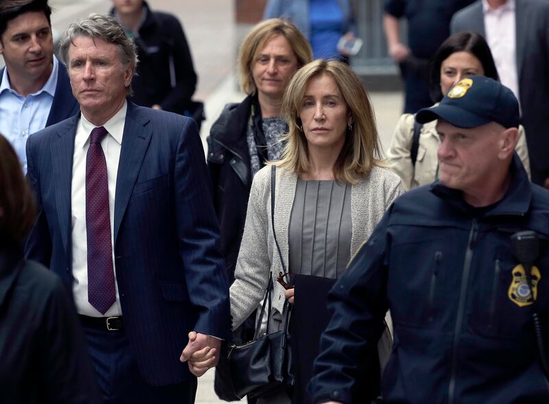 Felicity Huffman, center, departs federal court with her brother Moore Huffman Jr., left, Monday, May 13, 2019, in Boston, where she pleaded guilty to charges in a nationwide college admissions bribery scandal.
