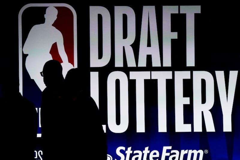People walk by a sign during the NBA basketball draft lottery in Chicago, Tuesday, May 16, 2023.