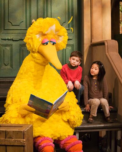 In this April 10, 2008, photo, Big Bird reads to Connor Scott and Tiffany Jiao during a taping of Sesame Street in New York. "Sesame Street" is celebrating their 50 anniversary this year.