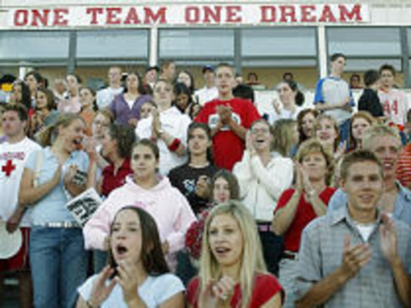 Spanish Fork High School football fans cheer for their team under a giant banner with Garrett Bardsley's name. The missing Scout's brother Jared plays for the team.