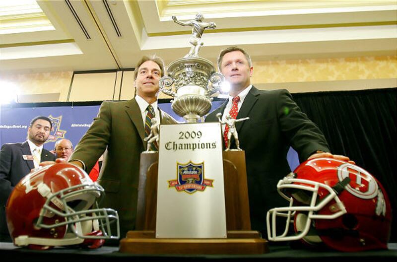 Utah coach Kyle Whittingham, right, and Alabama coach Nick Saban pose with the Sugar Bowl hardware on Thursday.