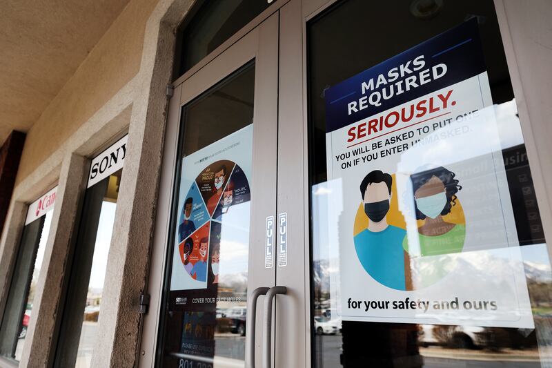 “Masks required” signage is pictured on the front doors of Pixels Foto & Frame in Utah.