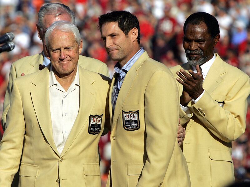 Former San Francisco 49ers quarterback Steve Young, center, stands on stage with former 49ers coach Bill Walsh, left, and former 49ers cornerback Jimmy Johnson