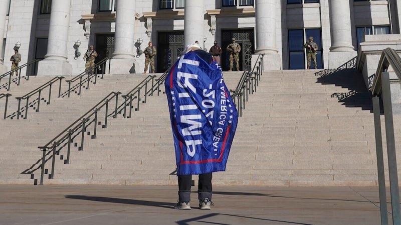 A Donald Trump supporter stands in front of the Utah State Capitol in Salt Lake City.