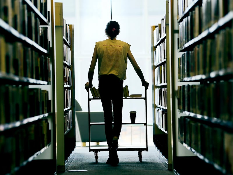 An employee at the Main Library in Salt Lake City pushes a cart between shelves of books on Sept. 21, 2020.