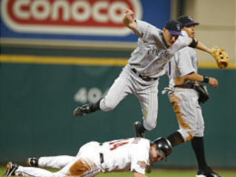 Colorado's Clint Barmes flies over Houston's Morgan Ensberg as he turns a double play on Saturday.