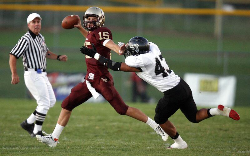 Lone Peak quarterback Chase Hansen throws a pass as Alta's Tupou Aagard tackles him during the first half of a football game at Lone Peak High School in Highland on Friday, September 24, 2010.