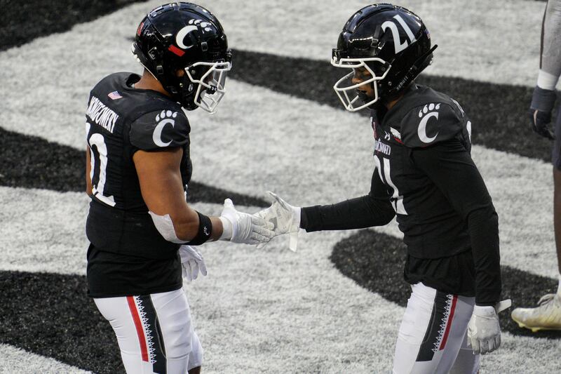 Cincinnati’s Tyler Scott celebrates with Ryan Montgomery after scoring a touchdown during an NCAA football game against Navy.