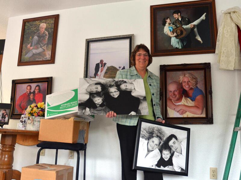 In this Sept. 18, 2012 photo, Kodiak, Alaska photographer Jan Pennington is seen with examples of her work in her studio on Mill Bay Road in Kodiak, Alaska. Pennington is closing her studio after 21 years in business.