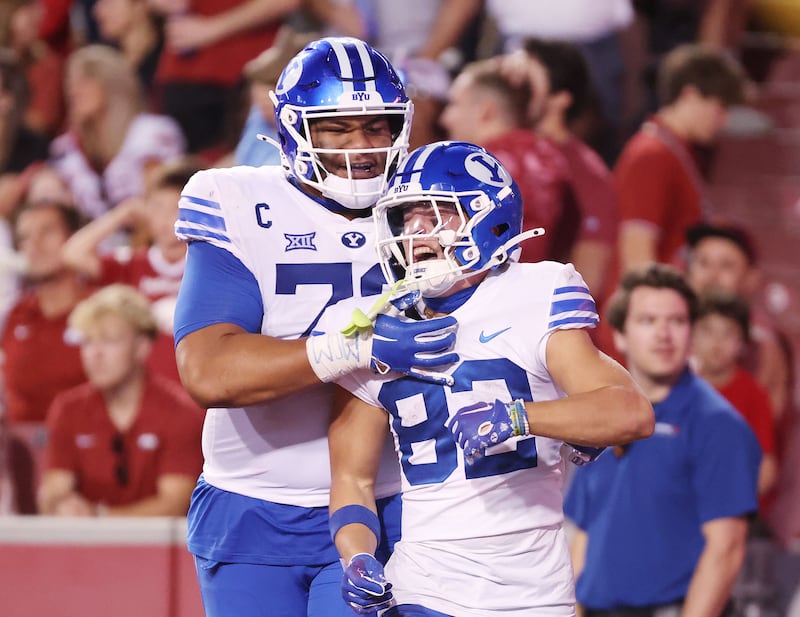 BYU receiver Parker Kingston (82) celebrates his TD with offensive lineman Kingsley Suamataia (78) at Razorback Stadium.
