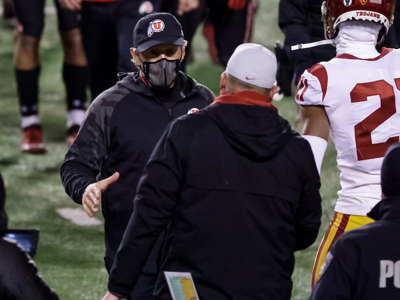 Utah Utes head coach Kyle Whittingham and USC Trojans head coach Clay Helton shake hands