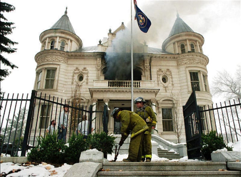 Firefighters cut open gates as smoke pours from Governor’s Mansion on Dec. 15, 1993.
