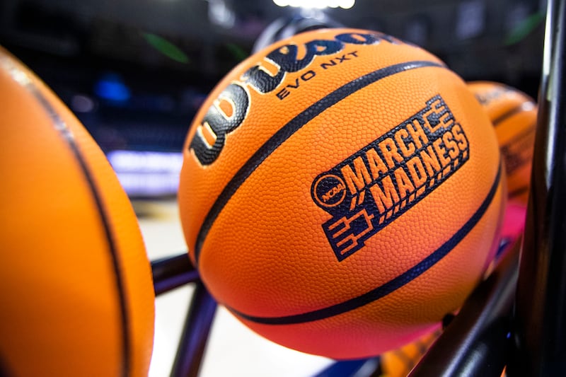 A basketball with a March Madness logo rests on a rack in South Bend, Ind.