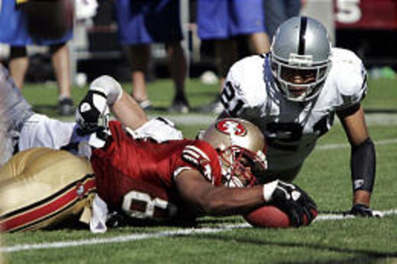 San Francisco's Arnaz Battle, center, reaches into the end zone to score against the Raiders.