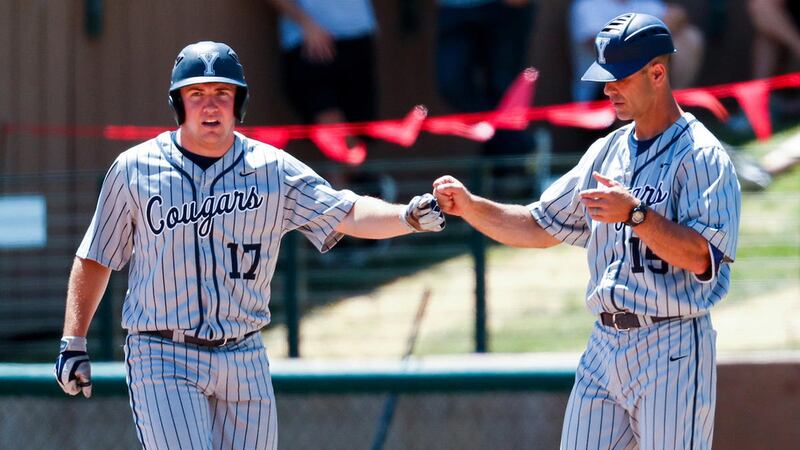 Outfielder Keaton Kringlen (left) gives a fist bump to Trent Pratt (right), who occupies the first base box when the Cougars are on offense.