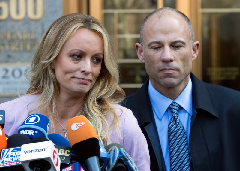 FILE - In this April 16, 2018 file photo, adult film actress Stormy Daniels, left, stands with her lawyer Michael Avenatti as she speaks outside federal court, in New York. Avenatti, the attorney who rocketed to fame through his representation of Daniels
