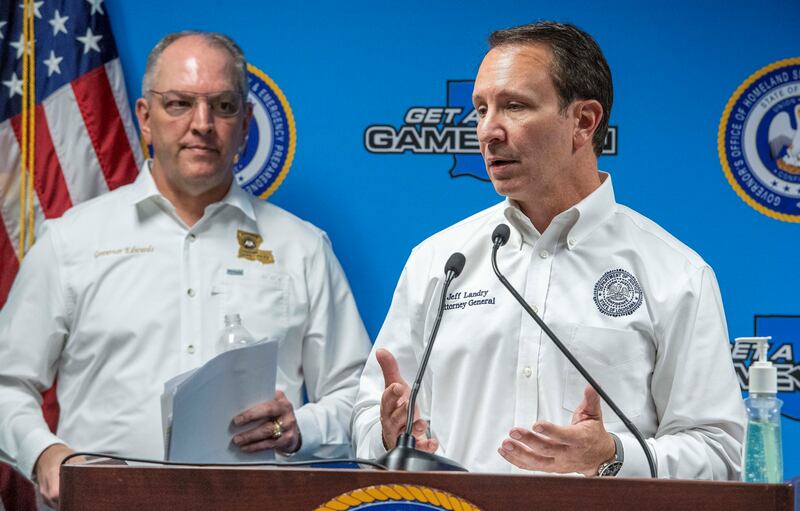 Louisiana Gov. John Bel Edwards listens as Attorney General Jeff Landry speaks.
