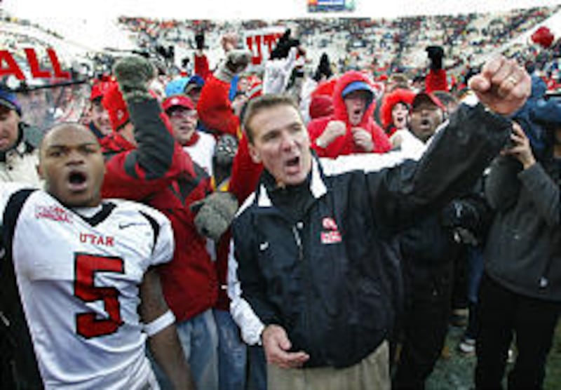 Utah running back Brandon Warfield (5) and coach Urban Meyer celebrate the Utes' win over BYU in Provo.