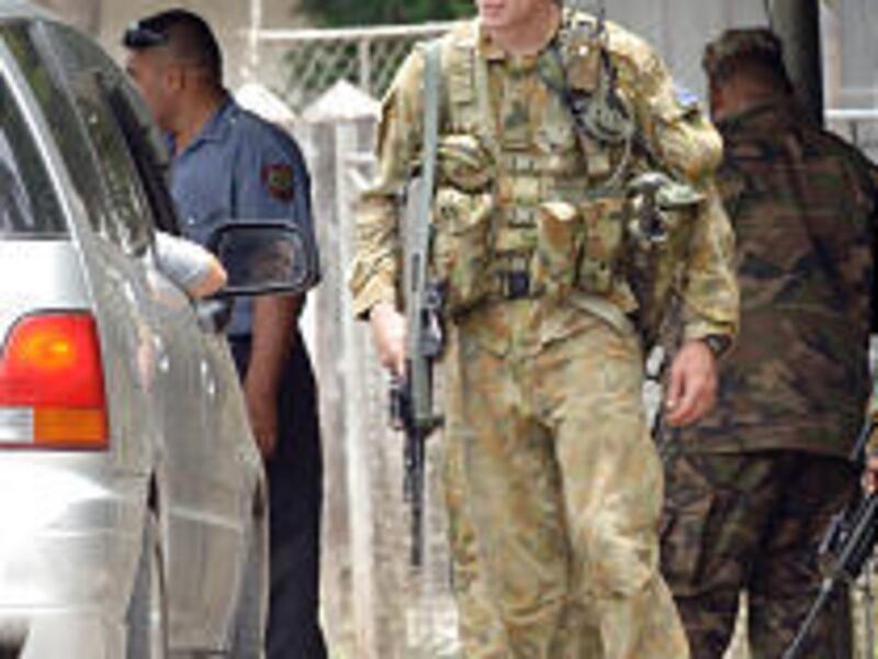 An Australian soldier looks over a car at a checkpoint in Nuku'alofa, Tonga, Wednesday.