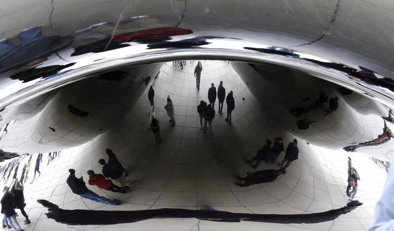 This is a Sunday, March 22, 2015. file photo of people as they are reflected by the Cloud Gate at Millennium Park in Chicago. Renowned artist Anish Kapoor has expressed outrage about the appearance of a sculpture in China that appears identical to his "Cl