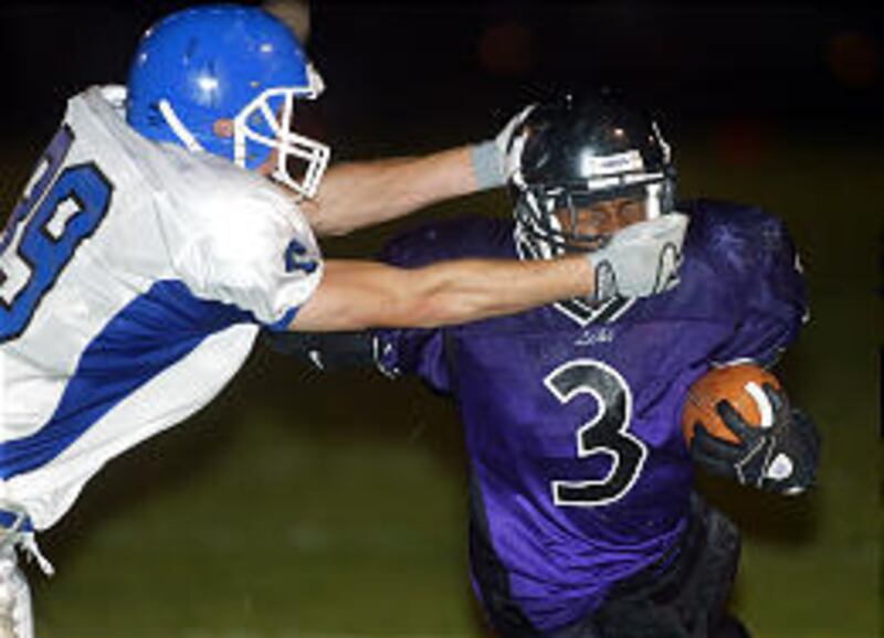 Carbon High's Bryon Stewart gets away with yanking on the face mask, but not until after Lehi's #3 Tyson Thompson gains good yardage in Friday night's game at Lehi. Lehi gained lots of ground vs. the Dinos.
