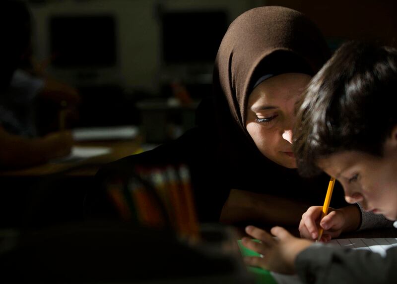 Baraa Huraideen helps son Eslam Hamad write in English during his first day at the Granite School District’s Tumaini Welcome & Transition Center in South Salt Lake on Wednesday, Aug. 23, 2017. Esalm and his brothers will spend two weeks at the center befo