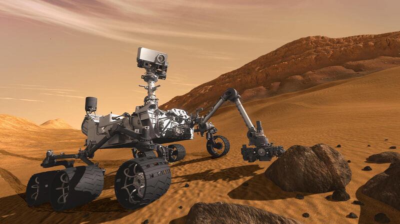 In this 2011 artist’s rendering the Mars Science Laboratory Curiosity rover examines a rock on Mars. Amid concerns over COVID-19, scientists at NASA are now being forced to pilot the rover from their homes.