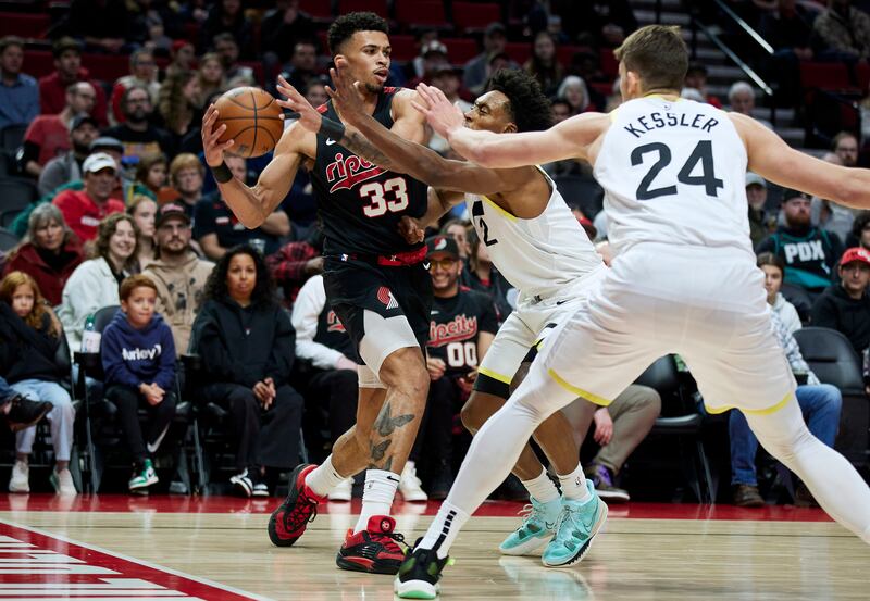 Portland Trail Blazers forward Toumani Camara, left, is defended by Utah Jazz guard Collin Sexton, rear, and center Walker Kessler during the first half of an NBA basketball game in Portland, Ore., Thursday, Dec. 14, 2023. (AP Photo/Craig Mitchelldyer)